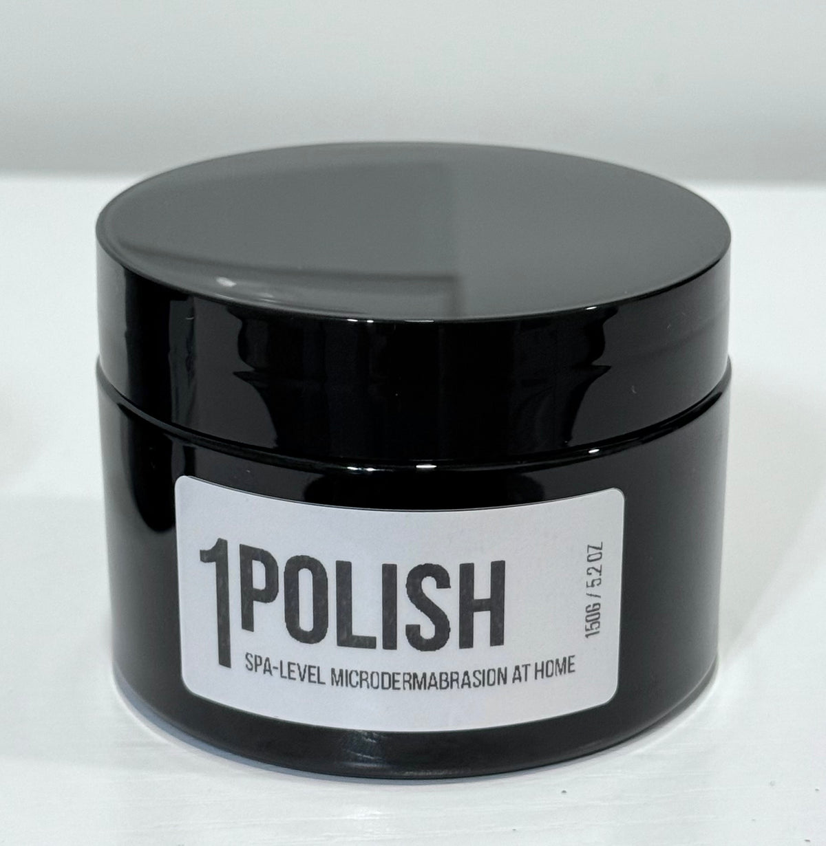 A black cosmetic jar from the brand Fafi’s best with white label reading 1 polish spa level microdermabrasion at home 150g 
